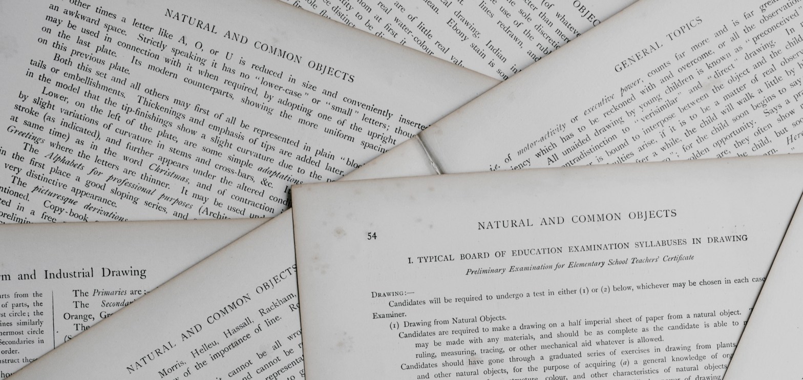 La imagen muestra un montón de hojas de papel dispuestas una encima de la otra de manera desordenada. El formato de las hojas es de un estilo parecido a un libro y tienen algunas manchas que indican que son documentos antiguos.