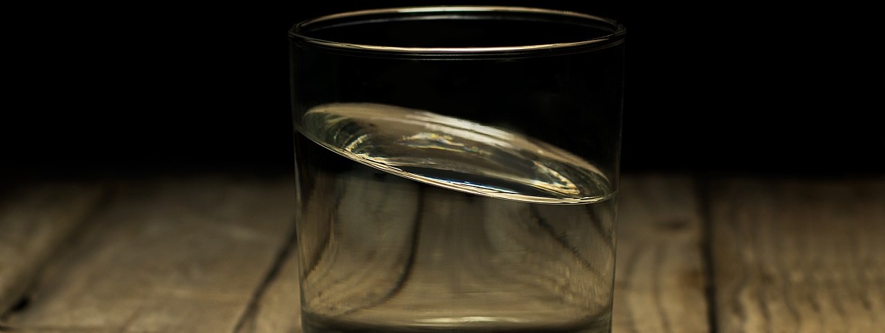 En la imagen se ve un vaso de cristal con un líquido transparente que está en movimiento.